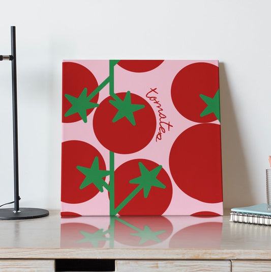 Decorative wall art with tomato design on a white wall above a wooden shelf.