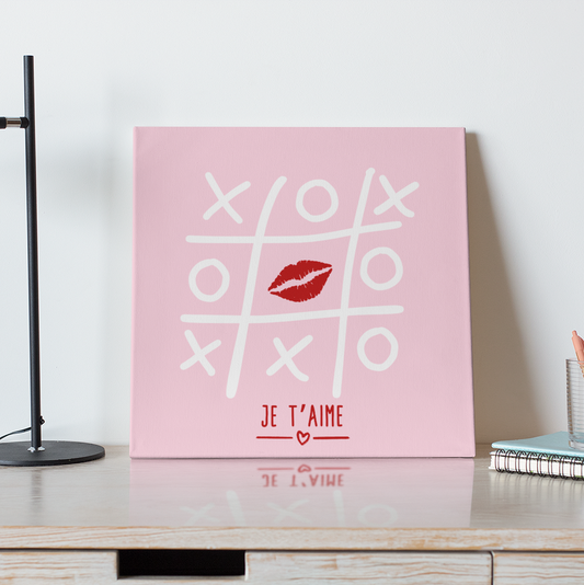 Decorative wall art with 'XO' and 'Je t'aime' on a pink background in a home office setting.
