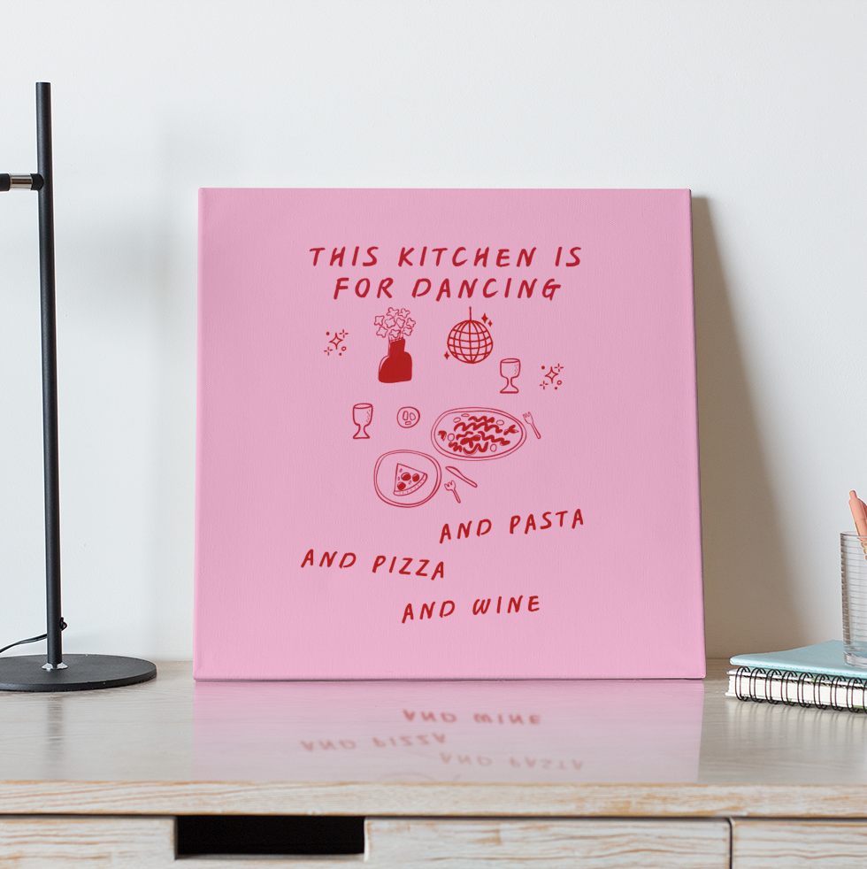 Pink poster with text on a wooden desk with a lamp and coffee cup.